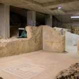 Una passerella in legno guida il turista tra mosaici e intonaci originali...